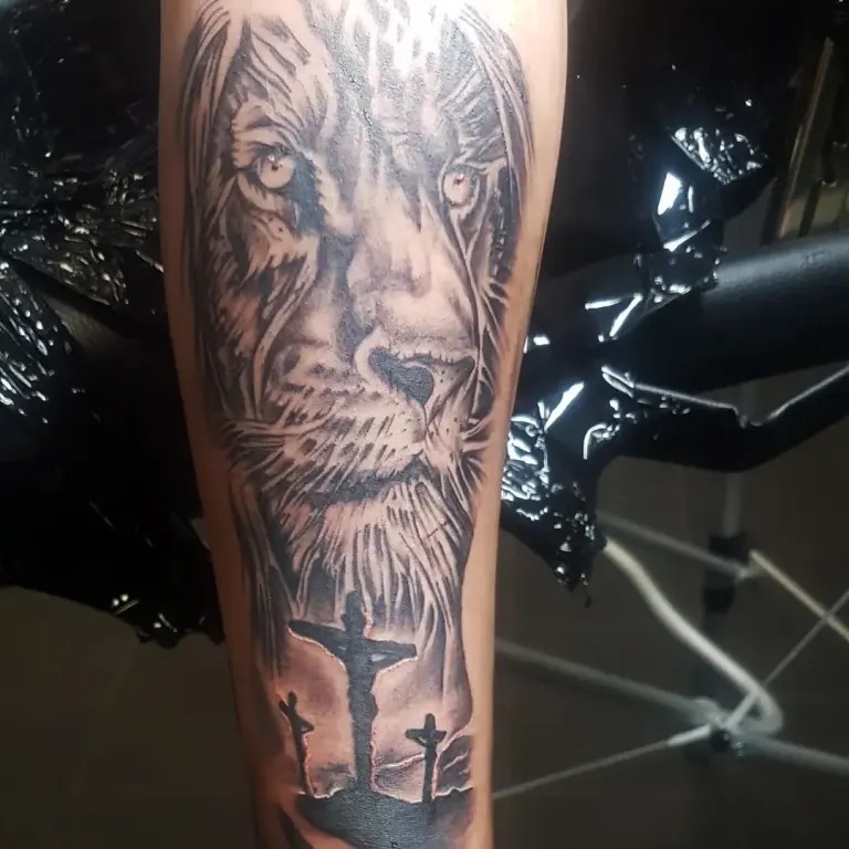 Black and grey realism lion tattoo with three crosses on a forearm, Canggu Bali